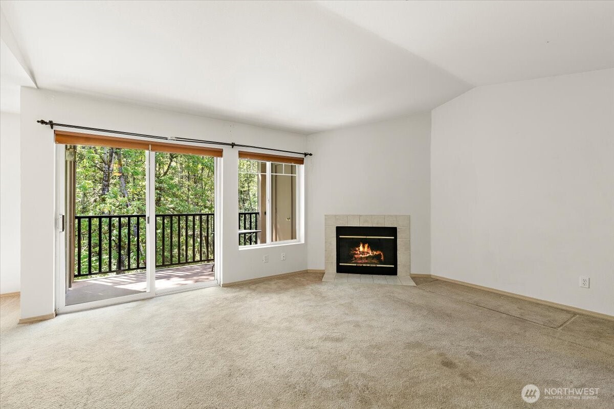 18930 Bothell Everett Highway, Unit B303 Bothell, WA 98012 - Photo 3 of 20 a view of an empty room with a fireplace and a window