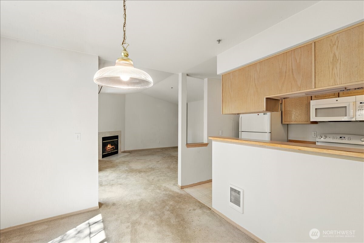 18930 Bothell Everett Highway, Unit B303 Bothell, WA 98012 - Photo 4 of 20 a kitchen with kitchen island a stove a sink and a refrigerator