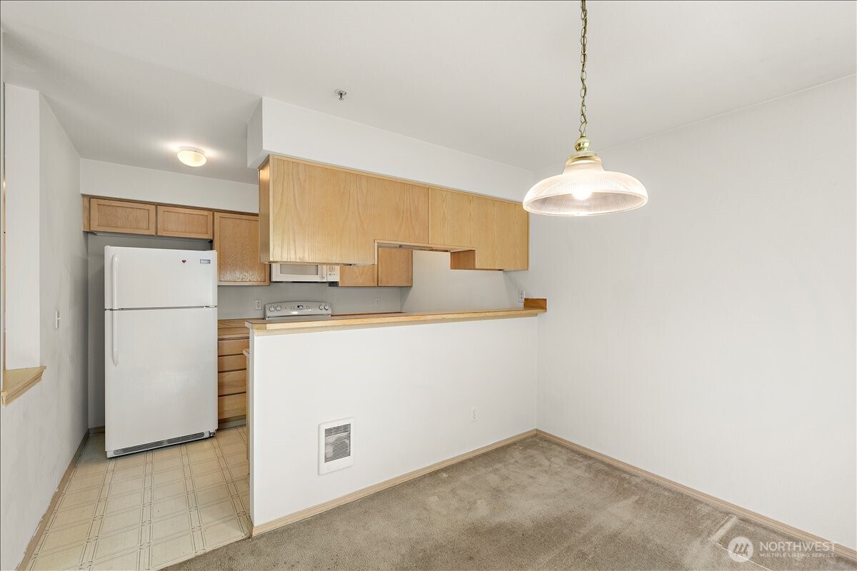 18930 Bothell Everett Highway, Unit B303 Bothell, WA 98012 - Photo 8 of 20 a kitchen with refrigerator and window