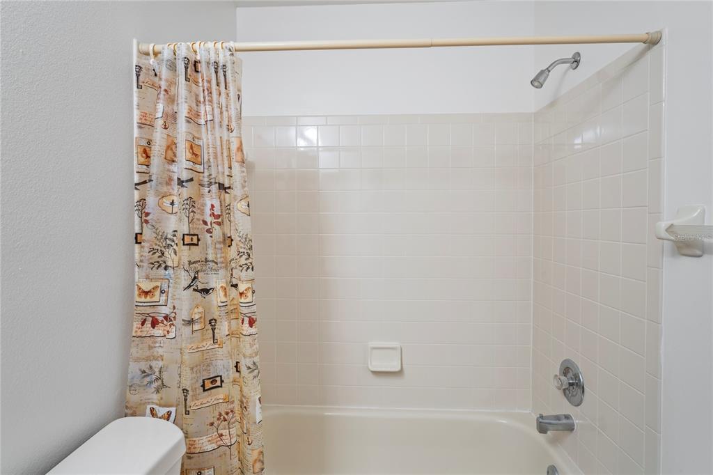 9108 Bassett Lane, Unit B New Port Richey, FL 34655 - Photo 33 of 66 a bathroom with a shower curtain a sink and a toilet