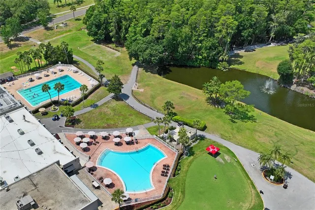 an aerial view of residential house with swimming pool and lawn chairs