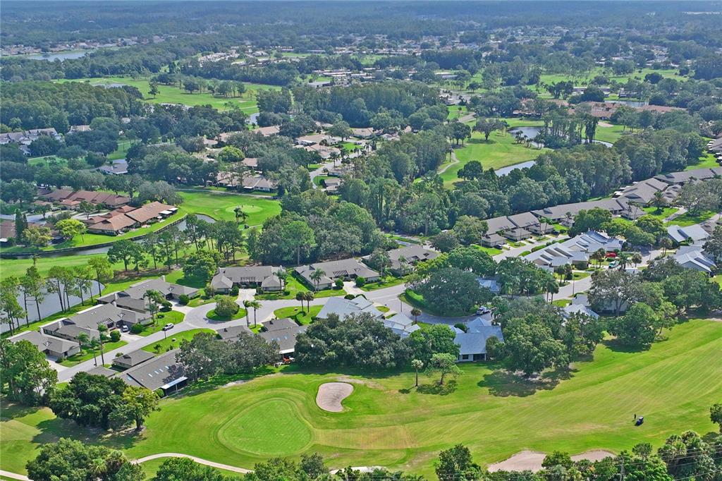 9108 Bassett Lane, Unit B New Port Richey, FL 34655 - Photo 51 of 66 an aerial view of residential houses with outdoor space and trees