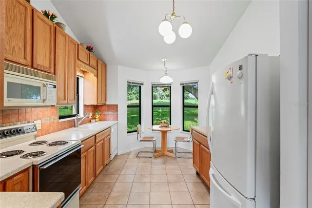 a open kitchen with stainless steel appliances granite countertop a stove and a refrigerator