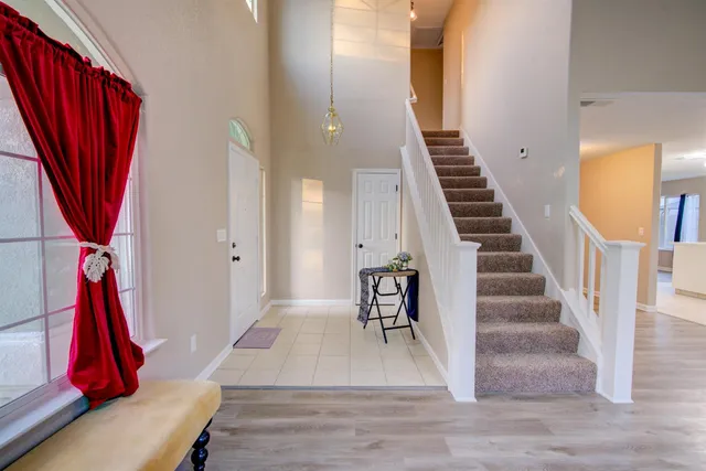 a view of a livingroom with wooden floor and stairs