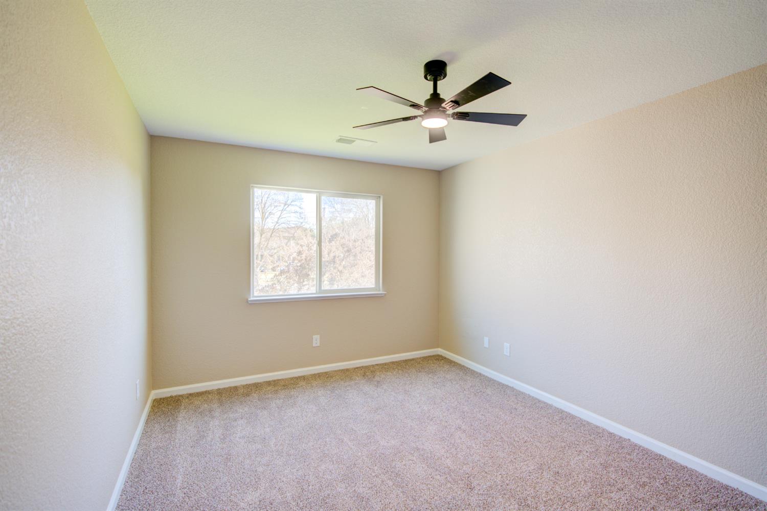 3546 Paseo Verde Avenue Merced, CA 95348 - Photo 20 of 24 an empty room with a window and a fan