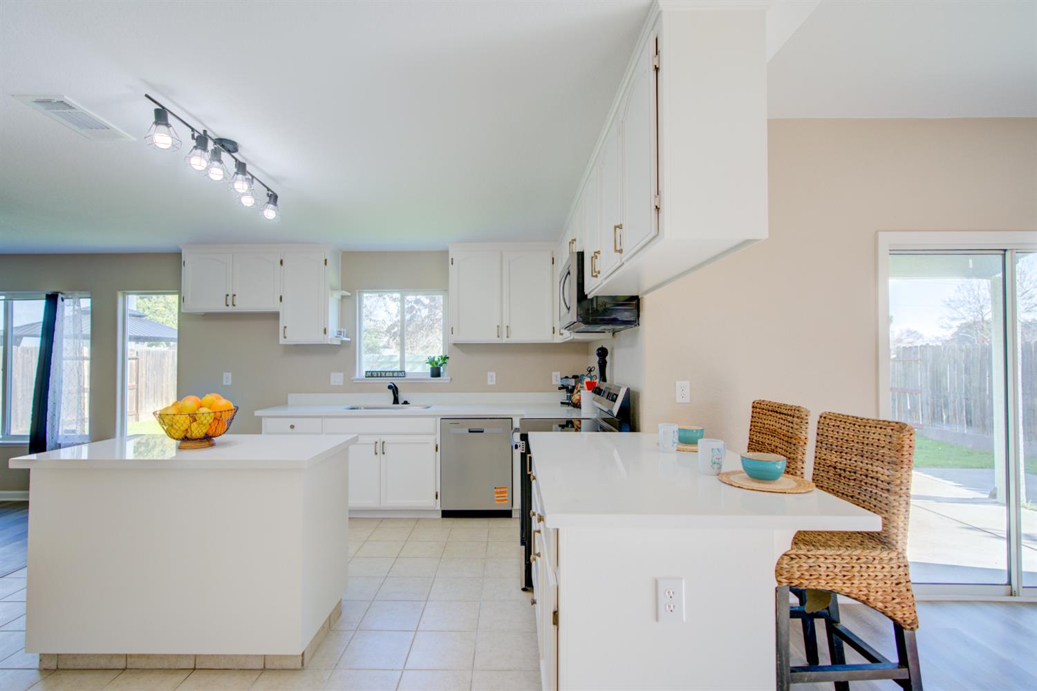 3546 Paseo Verde Avenue Merced, CA 95348 - Photo 6 of 24 a kitchen with a sink a stove and chairs