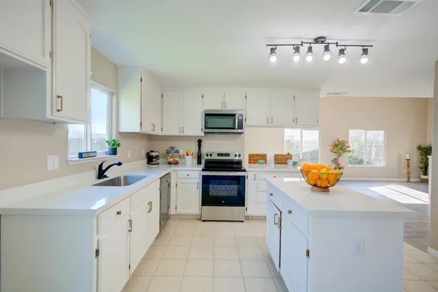 a kitchen with granite countertop a sink and dishwasher stove top oven