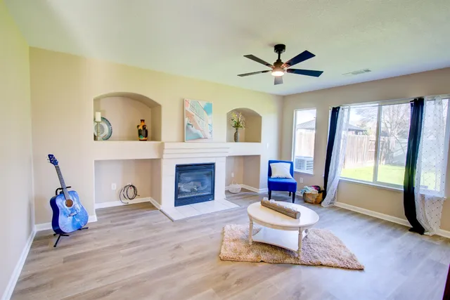 a living room with furniture a fireplace and a floor to ceiling window