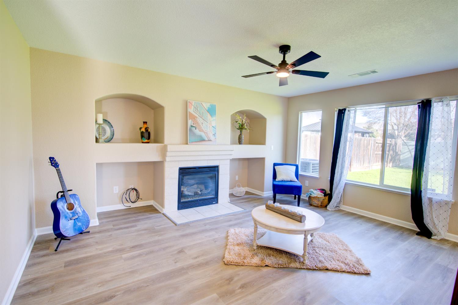 3546 Paseo Verde Avenue Merced, CA 95348 - Photo 9 of 24 a living room with furniture a fireplace and a floor to ceiling window