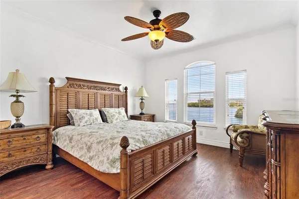 a bedroom with a bed a chandelier and dresser