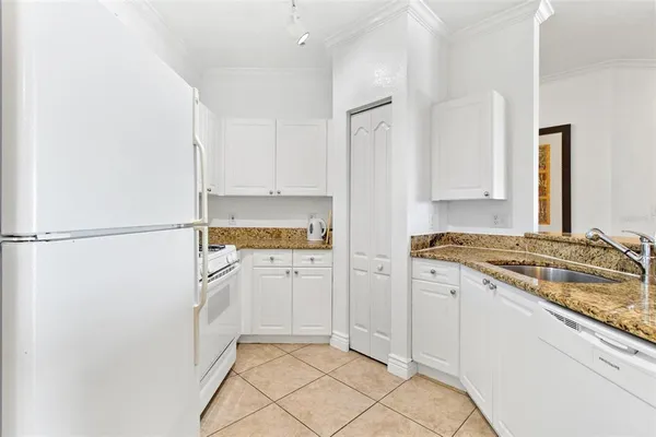 a kitchen with white cabinets and refrigerator