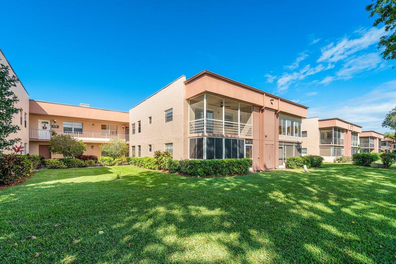 77 Normandy B Delray Beach, FL 33484 - Photo 1 of 34 a front view of a house with a yard