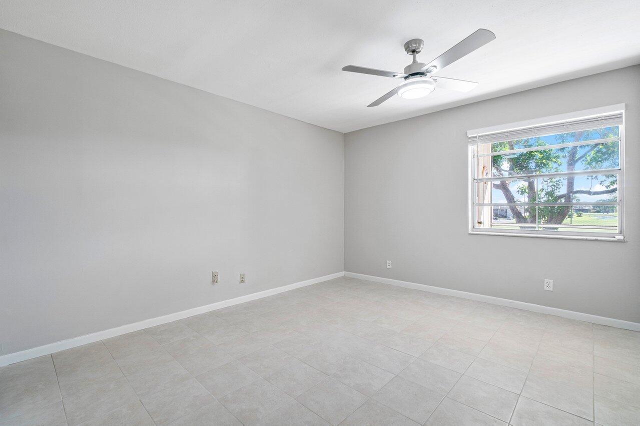 77 Normandy B Delray Beach, FL 33484 - Photo 8 of 34 an empty room with a window and a fan
