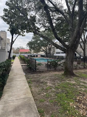 a view of a pathway with a wrought fence