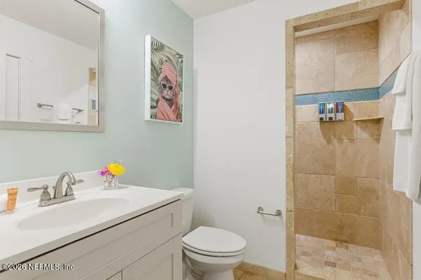 a bathroom with a sink vanity mirror and toilet