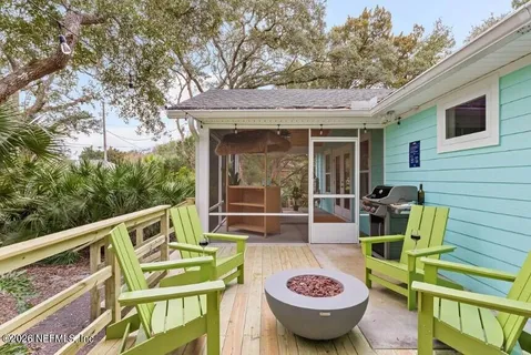 a view of a patio with couches chairs and wooden fence