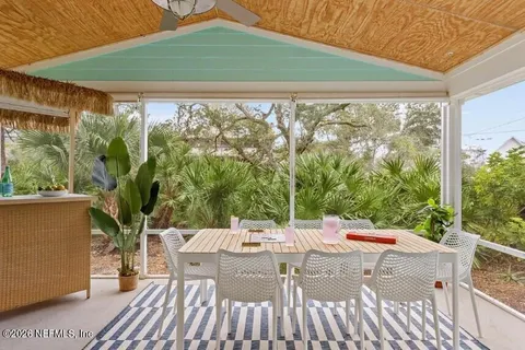 a view of a patio with a table and chairs under an umbrella