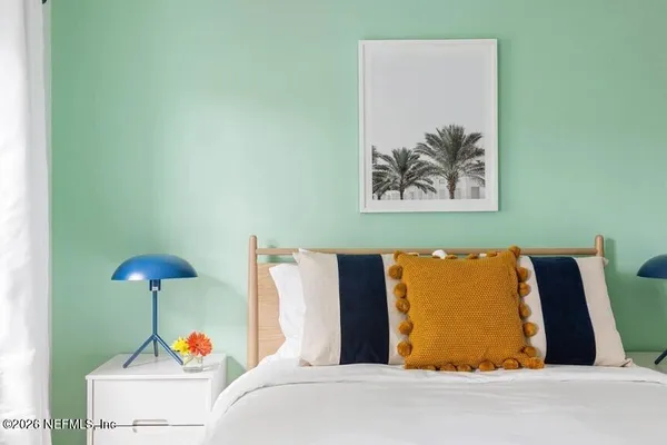 a bed room with a bed and a painting on the wall