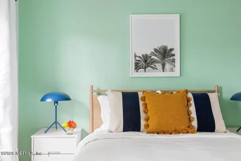 a bed room with a bed and a painting on the wall