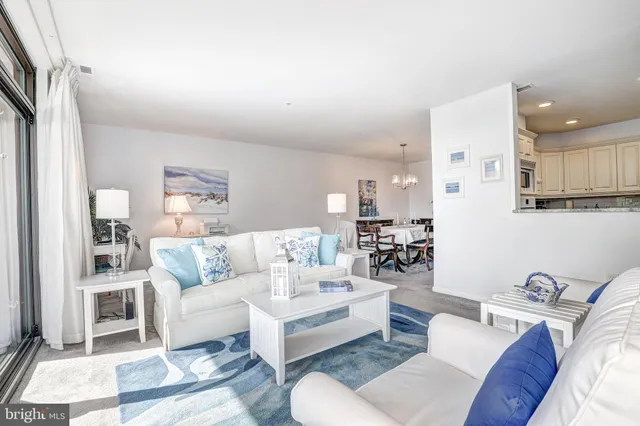 a living room with furniture and a view of kitchen