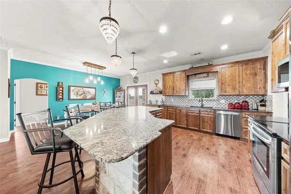 a kitchen with stainless steel appliances granite countertop a stove and cabinets