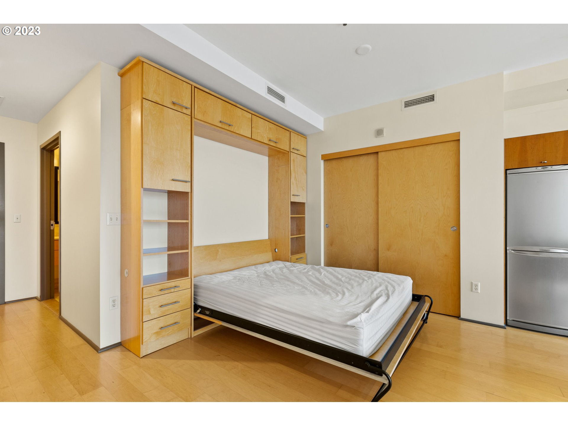 1221 Southwest 10th Avenue, Unit 914 Portland, OR 97205 - Photo 12 of 25 a bedroom with a bed and wooden floor