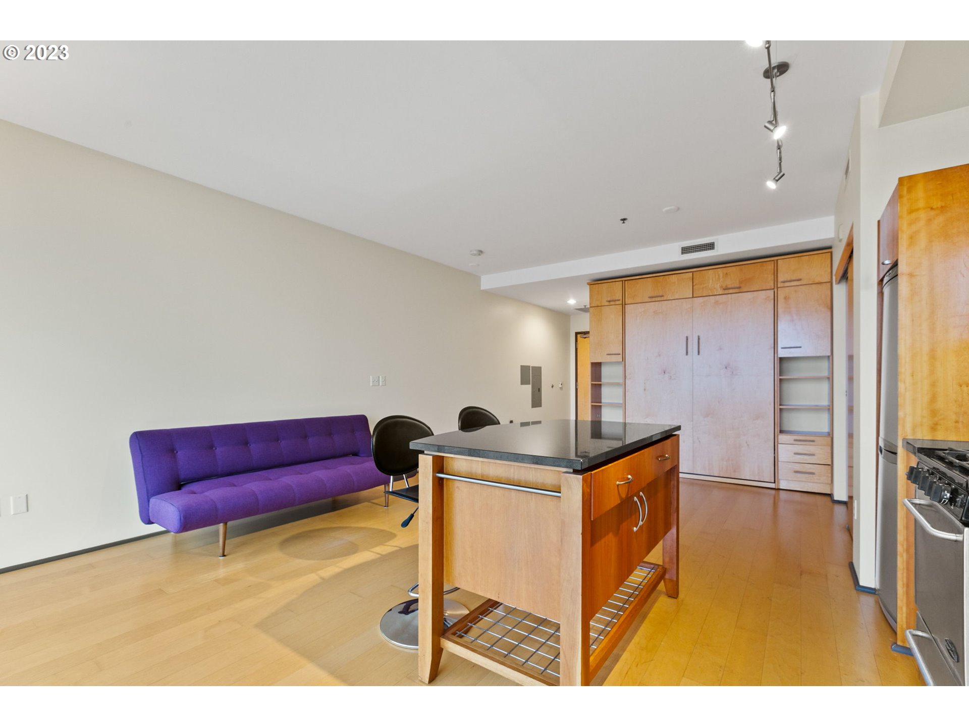 1221 Southwest 10th Avenue, Unit 914 Portland, OR 97205 - Photo 9 of 25 a kitchen with stainless steel appliances kitchen island granite countertop a table and chairs