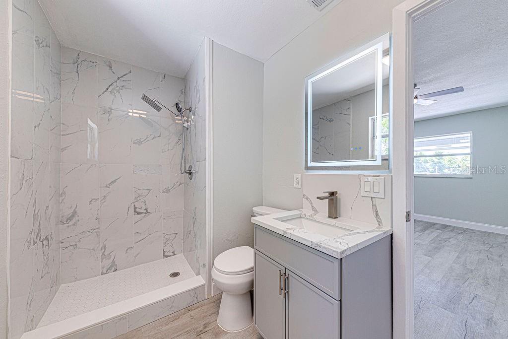 1133 Hermit Smith Road Apopka, FL 32712 - Photo 12 of 34 a bathroom with a granite countertop sink toilet and shower