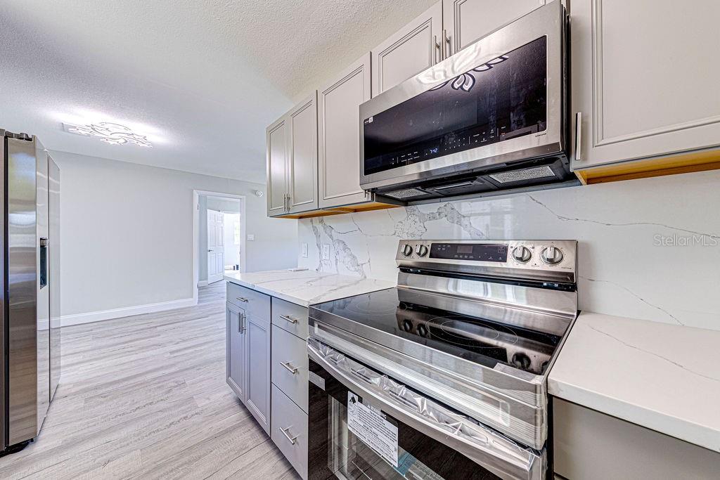 1133 Hermit Smith Road Apopka, FL 32712 - Photo 5 of 34 a kitchen with a microwave stove and cabinets