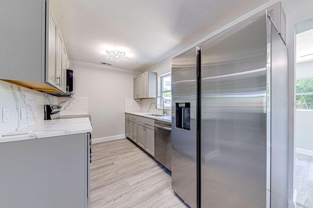 1133 Hermit Smith Road Apopka, FL 32712 - Photo 6 of 34 a kitchen with a refrigerator sink and cabinets