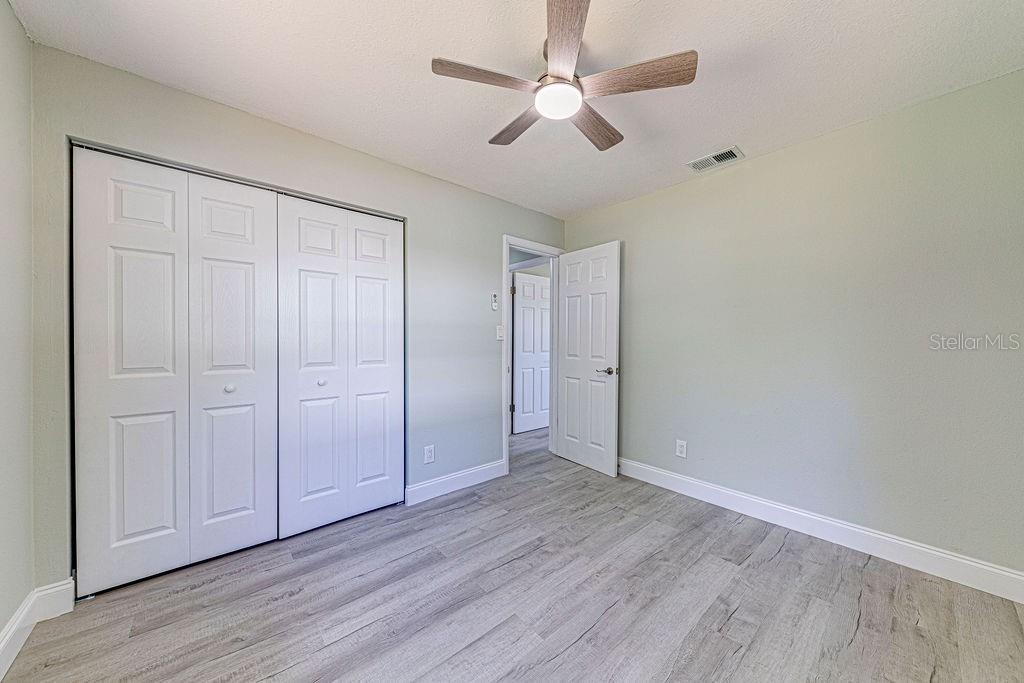 1133 Hermit Smith Road Apopka, FL 32712 - Photo 9 of 34 an empty room with wooden floor fan and windows
