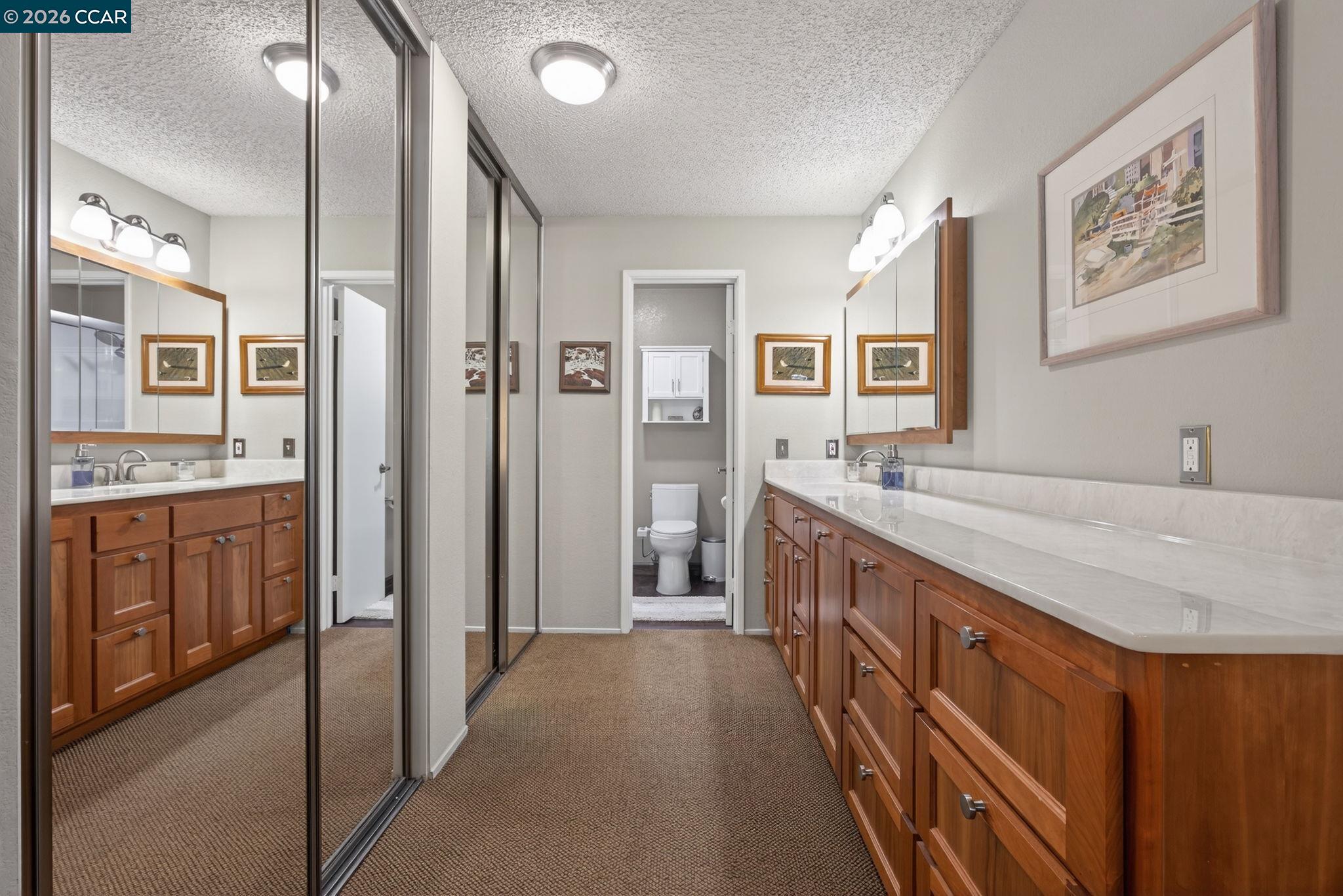 5015 Valley Crest Drive, Unit 121 Concord, CA 94521 - Photo 22 of 30 a spacious bathroom with a granite countertop double vanity sink a mirror and a shower