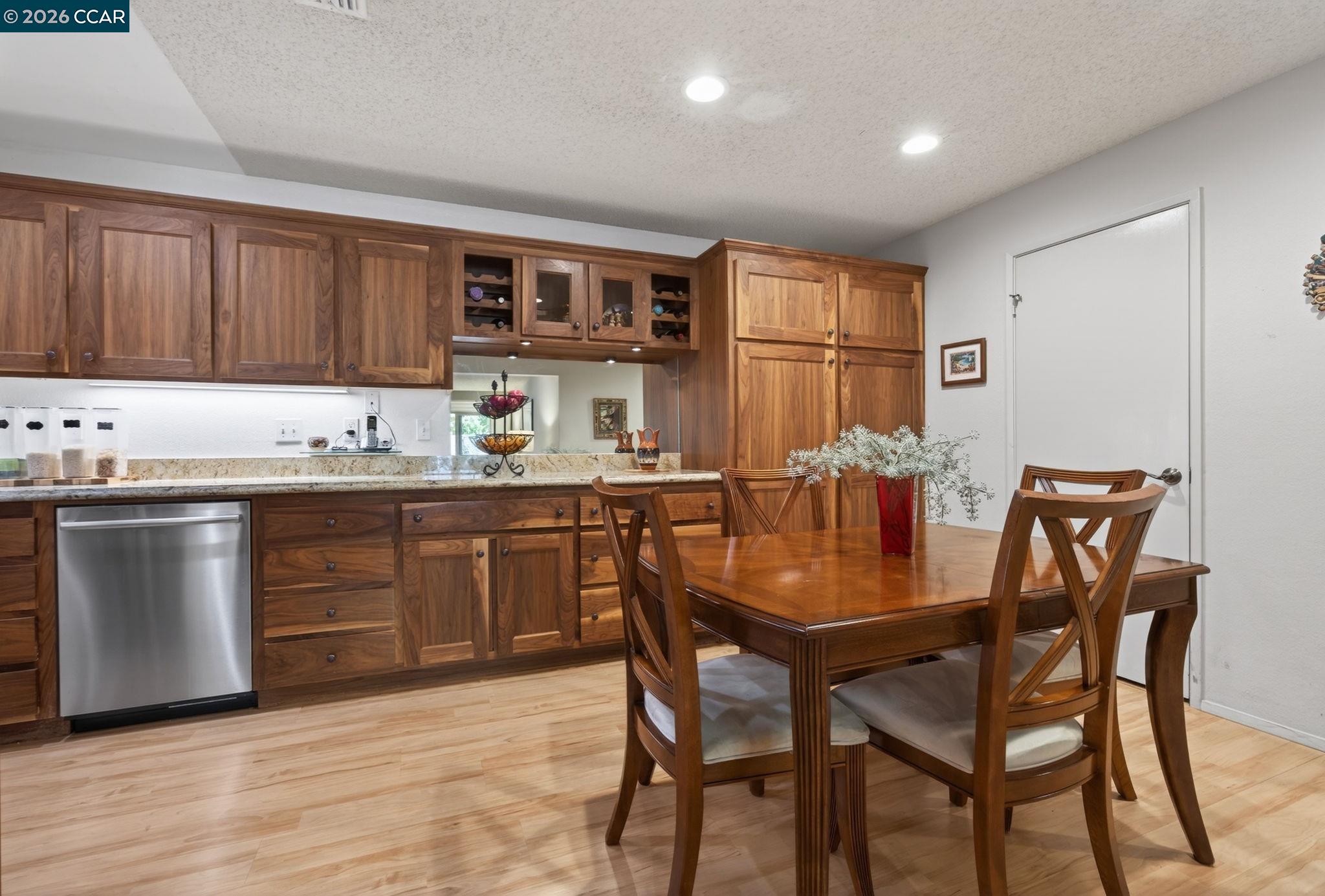 5015 Valley Crest Drive, Unit 121 Concord, CA 94521 - Photo 5 of 30 a kitchen with stainless steel appliances granite countertop a table chairs sink and cabinets