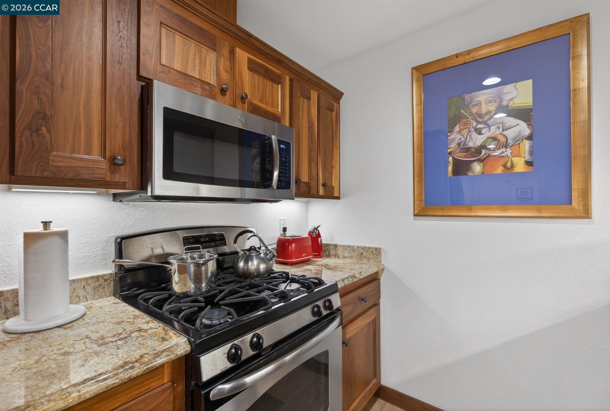 5015 Valley Crest Drive, Unit 121 Concord, CA 94521 - Photo 8 of 30 a kitchen with stainless steel appliances granite countertop a stove and a microwave