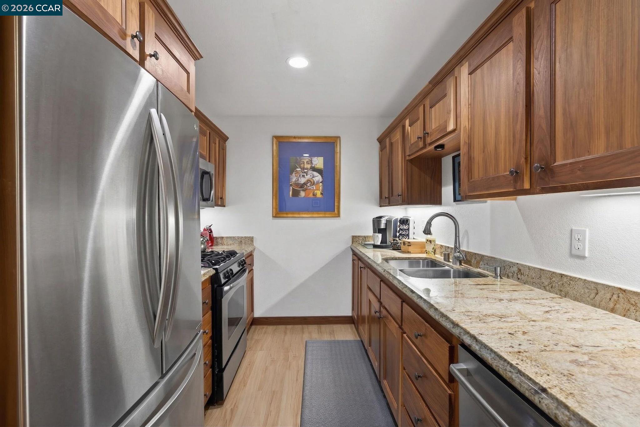 5015 Valley Crest Drive, Unit 121 Concord, CA 94521 - Photo 9 of 30 a kitchen with stainless steel appliances granite countertop a refrigerator a stove and a sink