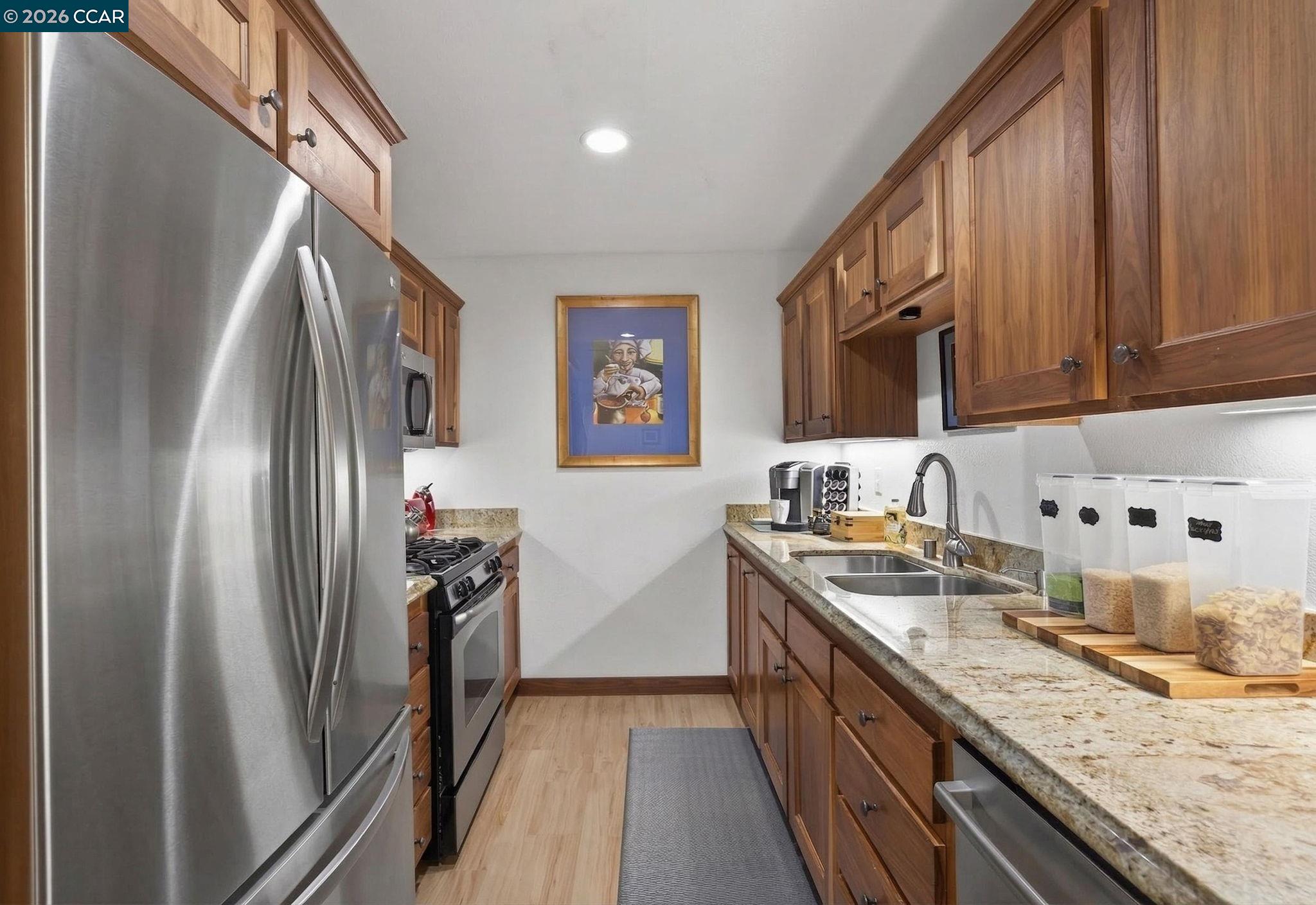 5015 Valley Crest Drive, Unit 121 Concord, CA 94521 - Photo 10 of 30 a kitchen with stainless steel appliances granite countertop a refrigerator a stove and a sink