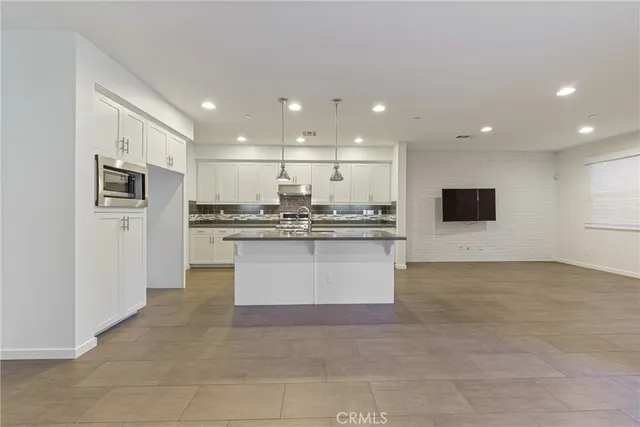 a view of kitchen with kitchen island a sink appliances and a couch