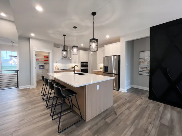 a kitchen with kitchen island white cabinets and stainless steel appliances
