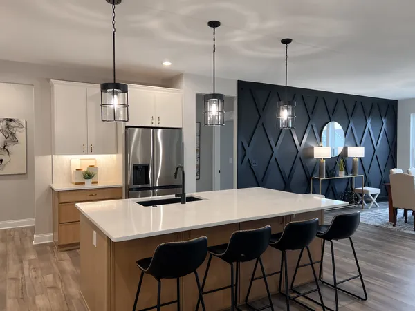a kitchen with stainless steel appliances a dining table chairs and wooden floor
