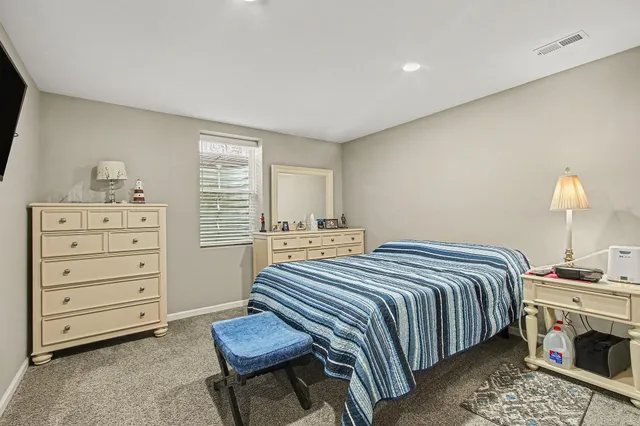 a bedroom with a bed and a dresser in it