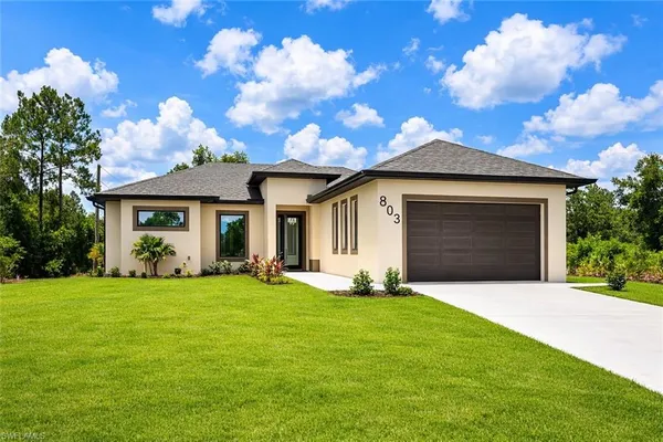 a front view of a house with a yard and garage