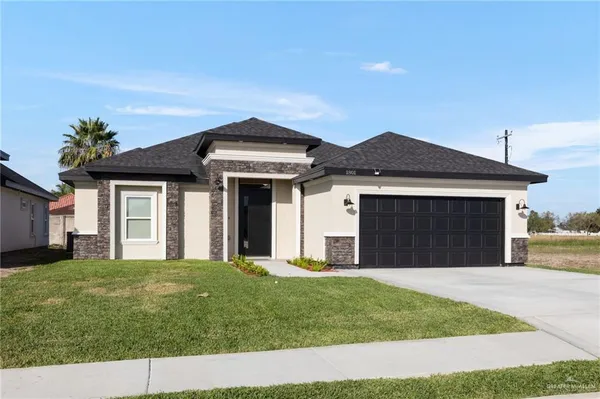 a front view of a house with a yard and garage