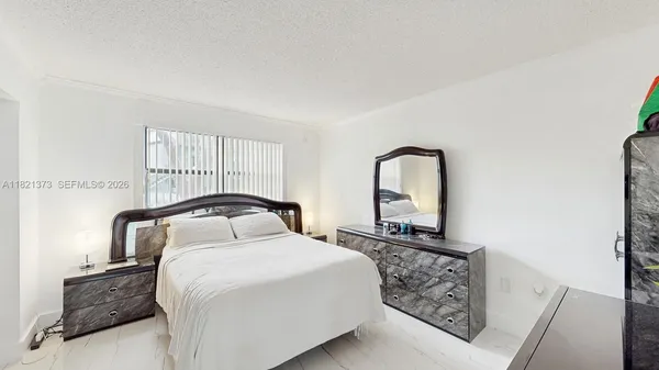 a bedroom with a bed and dresser with mirror