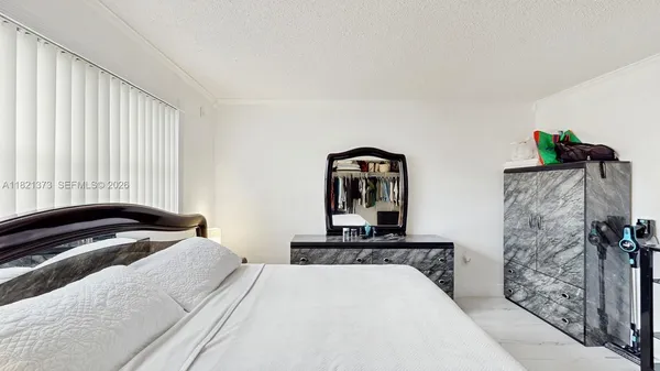 a bedroom with a bed and a dresser with mirror