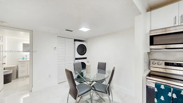 a view of a kitchen with a dining table and chairs