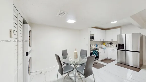 a kitchen with a refrigerator and a dining table