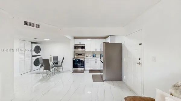 a kitchen with stainless steel appliances refrigerator wooden floor and chair