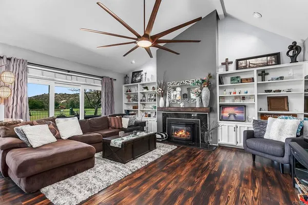 a living room with furniture pool table wooden floor and windows