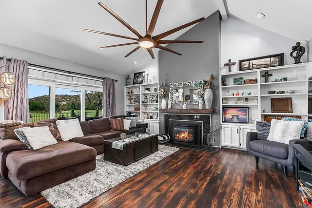 a living room with furniture pool table wooden floor and windows