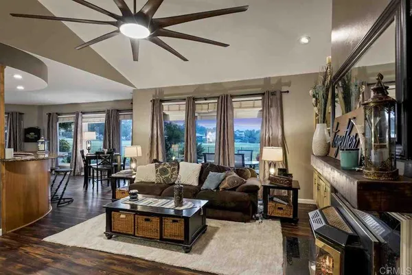 a living room with furniture a bookshelf and a large window